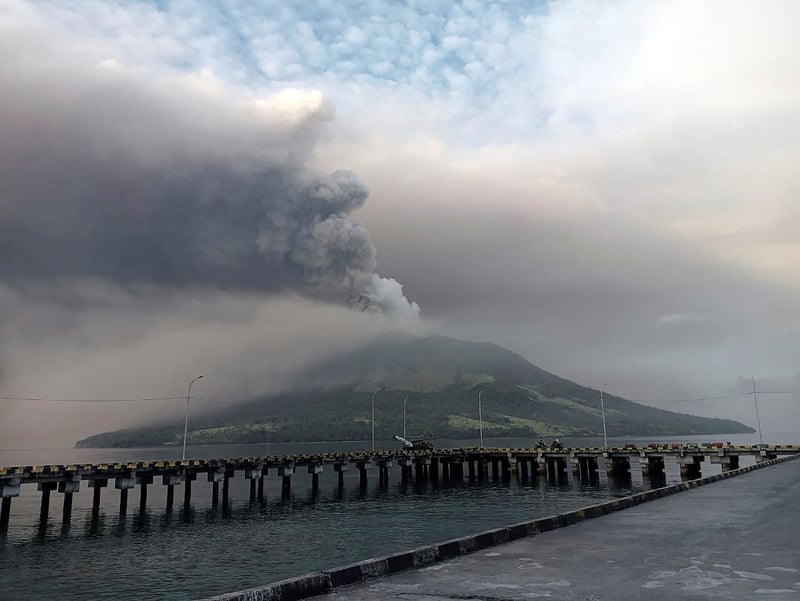 Indonesian volcano erupting near a bridge.