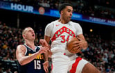 The Toronto Raptors' Jontay Porter secures a rebound in front of the Denver Nuggets' Nikola Jokic during an NBA game.