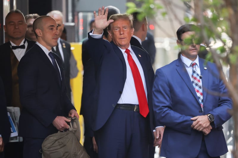 Donald Trump raises his hand.