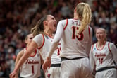 Four members of Virginia Tech's women's basketball team celebrate during a game.
