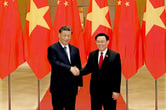 Xi Jinpinig and Vuong Dinh Hue shake hands in front of Vietnamese and Chinese flags.