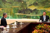Antony Blinken and Xi Jinping at a conference table.