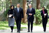 Xi Jinping and Olaf Scholz walk outdoors.