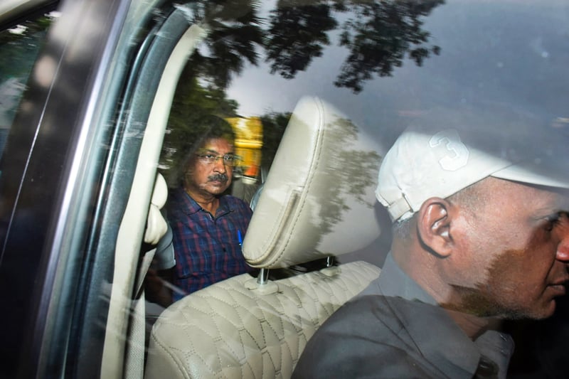 Arvind Kejriwal rides in the back of a vehicle.