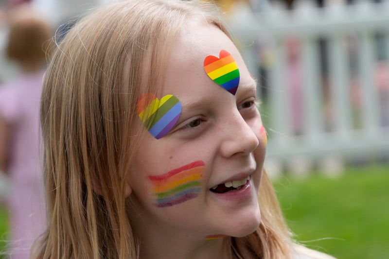 A young girl with LGBT-themed hearts and face paint.