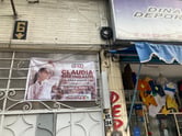 A political poster above an apartment doorway for presidential candidate Claudia Sheinbaum in Mexico City.