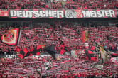 Bayer Leverkusen's stadium with fans in red and black.