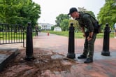 A U.S. Park Police officer examine a damaged barrier in Lafayette Square park near the White House.