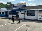 Two Malaysian police officers examine the scene of a shooting outside a police station.