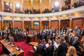 Politicians stand in the Serbian parliament building.