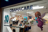 A large Obamacare decal on the window of an insurance agency office.