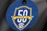 A luggage tag with the Southeastern Conference logo that notes the 50 years of Title IX.