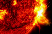 A solar flare on the sun captured in the extreme ultraviolet light portion of the spectrum colorized in red and yellow.