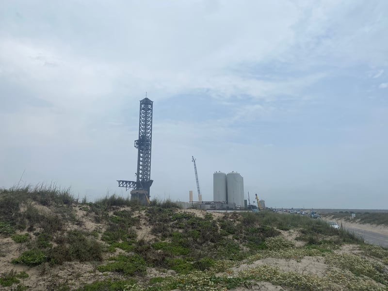 SpaceX launch site with sand dunes and beach in foreground