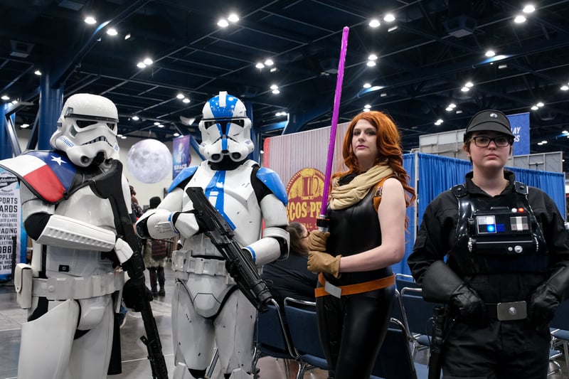 Four people standing togther dressed in various "Star Wars" costumes.