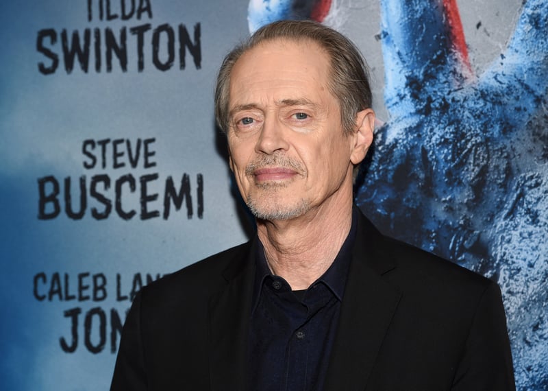 Steve Buscemi poses for photos in front of a wall with his name on it.
