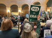Supporters hold up "YES on ERA!" signs during an event at the Minnesota Capitol building.
