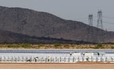 Workers build rows of solar panels at a Mesquite Solar 1 facility.
