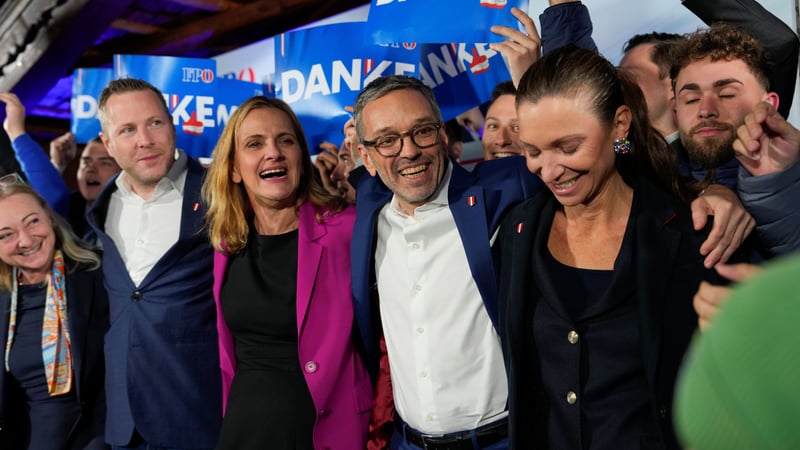 Members of Austria's Freedom Party celebrate with arms around each other's shoulders and supporters raising blue signs that say "danke," "thank you in German."