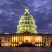 The U.S. Capitol lit up under cloud-filled skies.