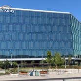 Glass building with company logo near the roof.