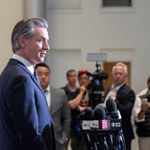 A man standing in front of microphones at a press conference