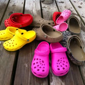 A pile of Crocs shows in various colors