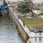People stand on an overlook above a river