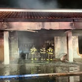 Firefighters extinguish a smoldering car inside a burned entrance of a U.S. Post Office.