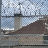 View of prison cells and a guard tower at Oahu Community Correctional Center in Honolulu, seen from outside the facility fence.