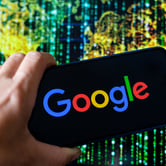 A hand holds a smartphone with the Google logo against a backdrop of a green, yellow and black digital world map.