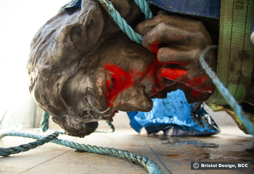 A close-up of the statue's head after being recovered from the harbor. Red spray paint has been applied to the eyes, mouth, and right hand. 