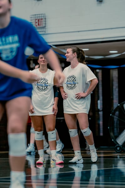 A player in white stands with hands on hips, looking to the side.