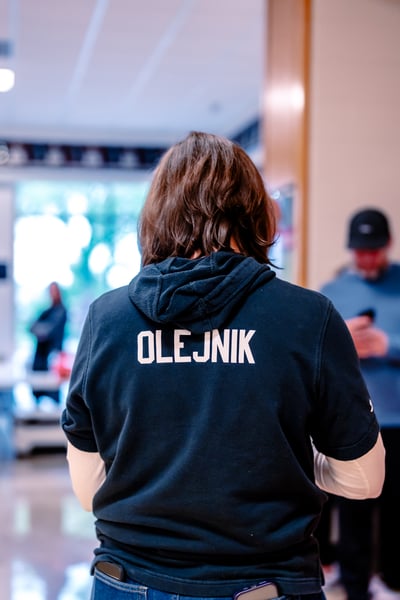 A person in a black hoodie stands with their arms crossed.
