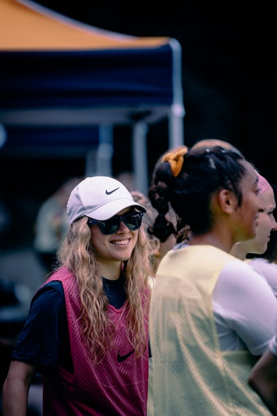 A player in a pink vest and a player in a yellow vest stand together.