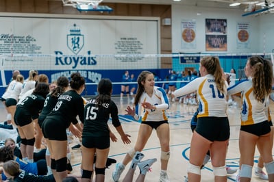 A player in white and blue reaches out to a player in black.