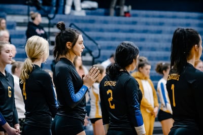 A player in black claps her hands together.