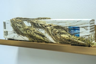 A model train car with a textured, organic material covering it.