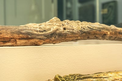 A textured sculpture rests on a white shelf.