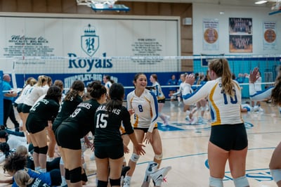 A player in white and blue smiles and extends her hands.