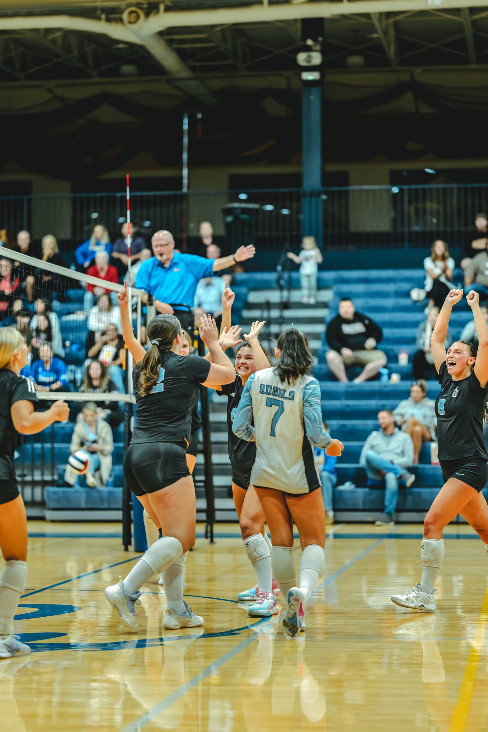 Players in black and white jerseys celebrate on the court, with player 1 in black and player 7 in white visible.