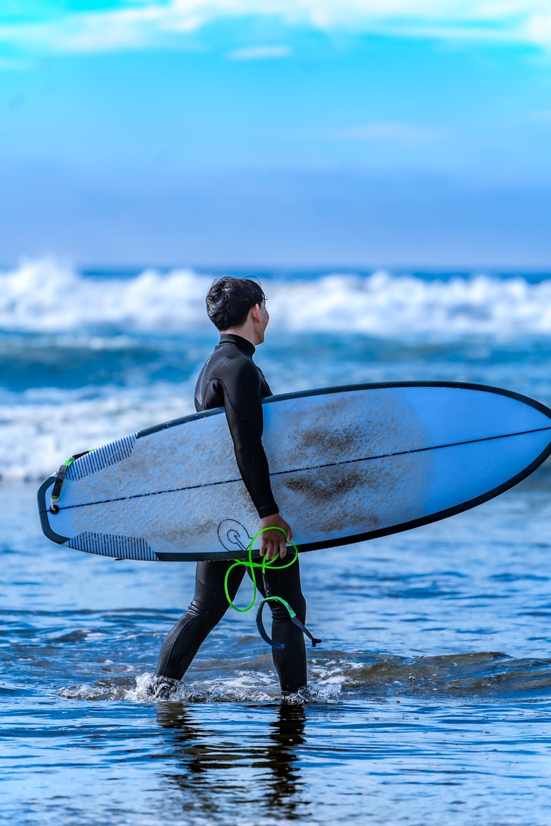 A surfer carrying a board into the water