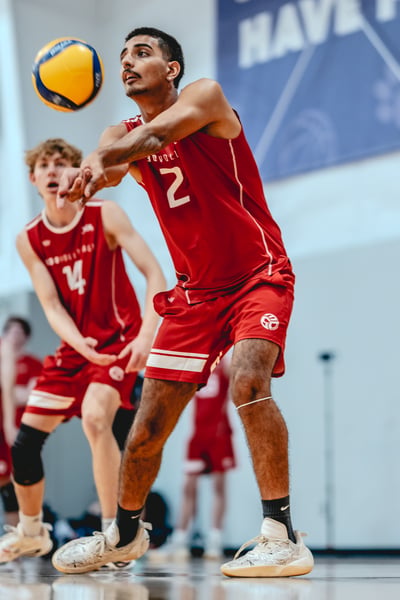 A player in red reaches forward with arms extended.