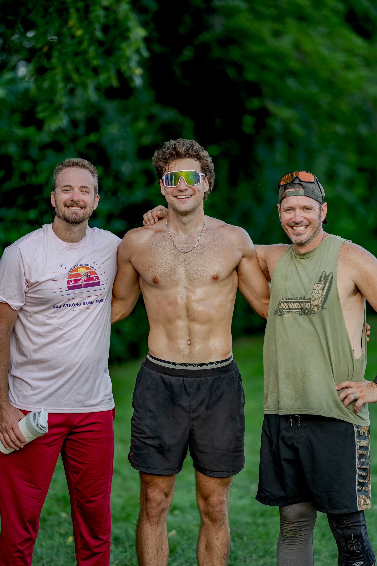 Three players in athletic wear pose for a photo at the Bump Bash charity volleyball tournament.