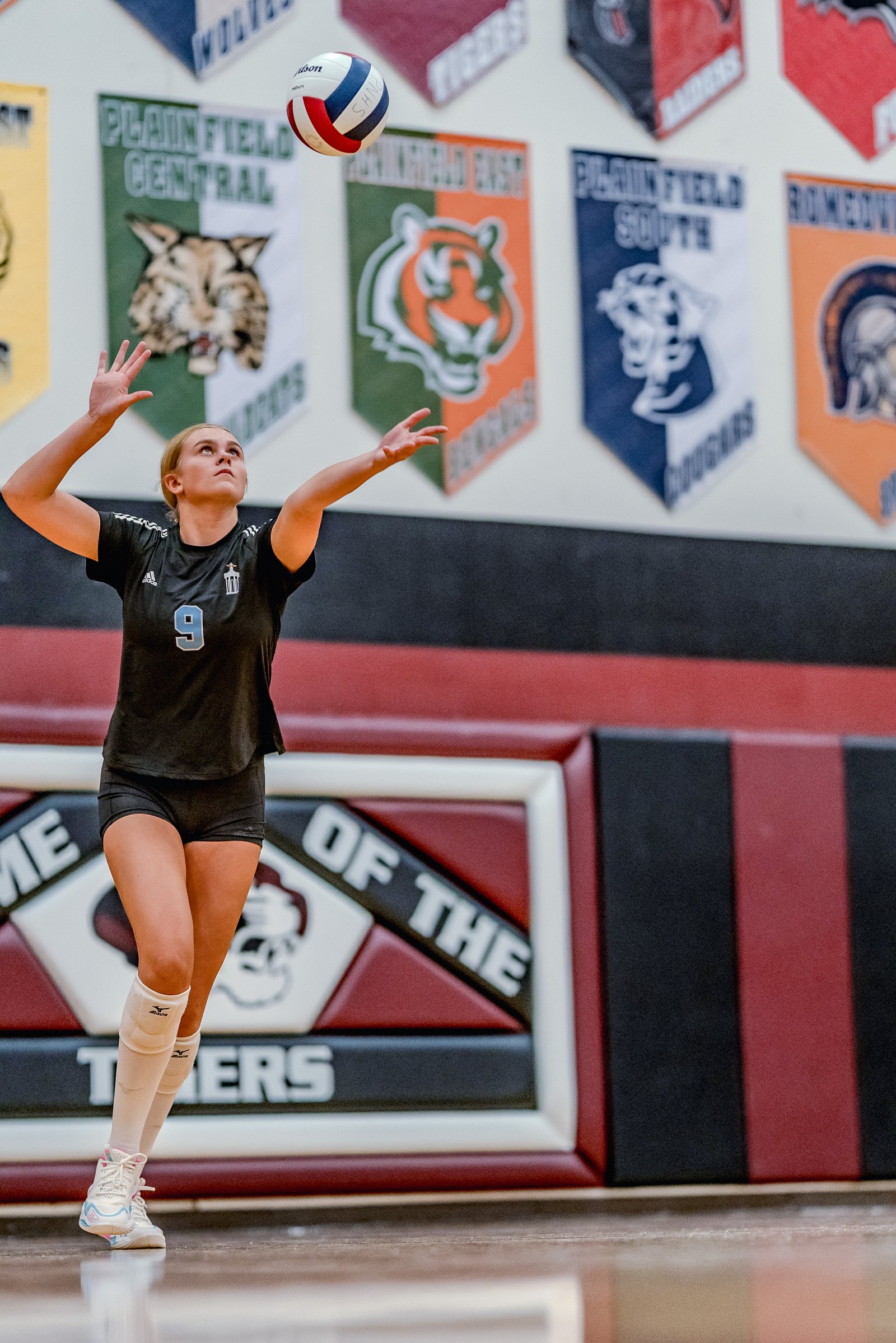 A player in a black top with number 9 sets the volleyball during a game against PNHS.