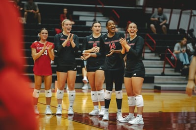 A North Central player in black claps hands with other players in black.
