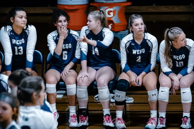 a player in a navy uniform gestures while talking to teammates.