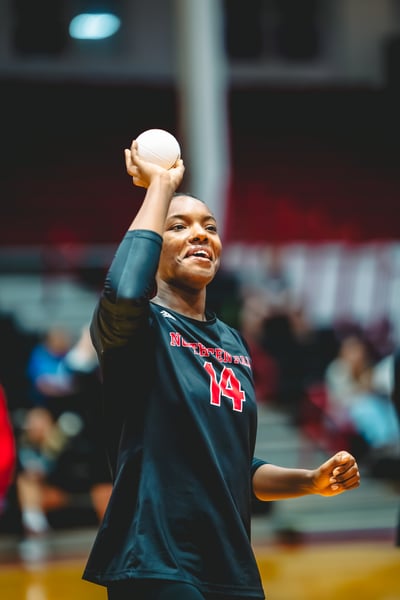 A player in black holds a ball overhead.