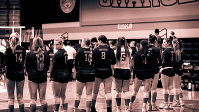 A team in black uniforms stands facing away from the camera.