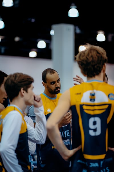 A player in a yellow and blue uniform looks down at another player in a yellow and blue uniform.